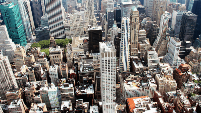 A cityscape filled with high-rise commercial buildings, emphasizing the importance of selecting durable roofing systems for urban structures.