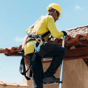 A roofing contractor in safety gear climbs a ladder to inspect and secure a commercial roof, highlighting the importance of hurricane preparedness by reinforcing roofing materials and ensuring structural stability before storm season.