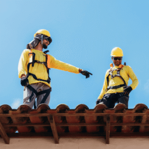 two roofing contractors in safety harnesses inspecting a commercial roof, emphasizing the importance of checking HVAC units and flashing to prevent leaks and ensure proper sealing.