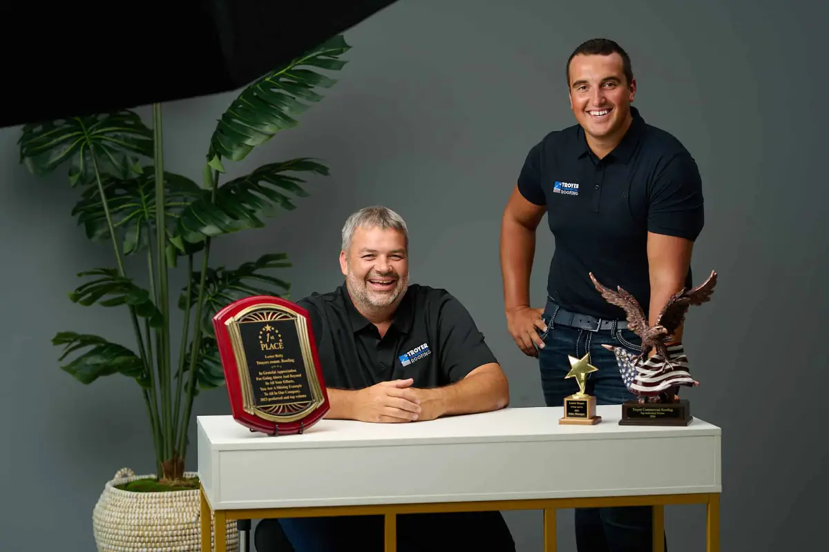 Troyer Commercial Roofing team with awards and certifications, showing why working with licensed contractors prevents roofing scams.