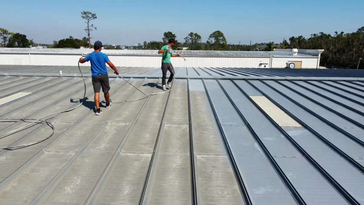 Troyer Commercial Roofing crew applying roof coating on a Florida commercial property, demonstrating their commitment to never cutting corners.